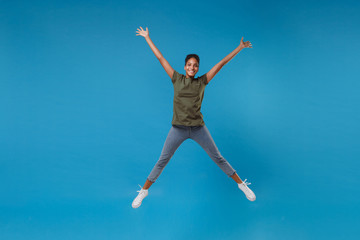 Fototapeta na wymiar Funny young african american woman girl in casual clothes posing isolated on bright blue background studio portrait. People lifestyle concept. Mock up copy space. Jumping, spreading hands and legs.