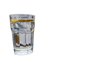 Glass of sparkling water with lemon slices isolated on white.
