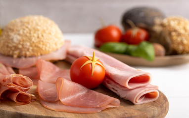Breakfast table with smoked and cooked ham and bread on a plate