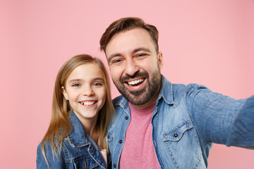 Obraz premium Close up of laughing bearded man with cute child baby girl. Father little kid daughter isolated on pastel pink background. Love family parenthood childhood concept. Doing selfie shot on mobile phone.