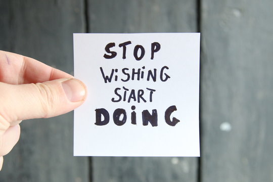 stop dreaming start doing, motivational inscription on a sheet of paper