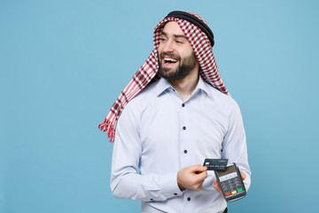 Cheerful arabian muslim man in keffiyeh kafiya ring igal agal isolated on pastel blue background....