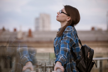 Woman contemplating views on a balcony looking at city scape