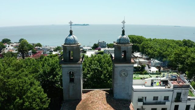 Colonial street and houses at summer day, aerial view. Basilica del Sant simo, Colonia. Uruguay.