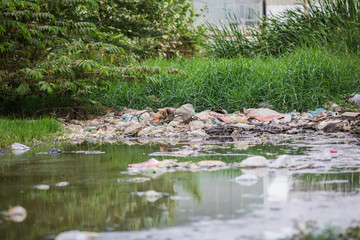 Fototapeta na wymiar Discarded garbage near the water's edge