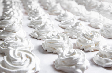 on a white pastel background lies a fresh white handmade marshmallow. copy space