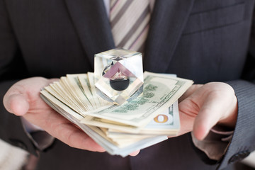 Businessman in suit, tie holds in hands drop of black oil of Brent brand in crystal cube.Pack of...