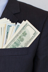 Pack of hundred dollars bills in pocket of suit of businessman in shirt and tie. Successful...