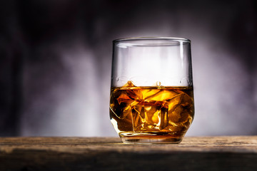 Faceted glass of whiskey with ice