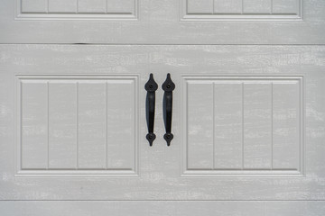 Elegant black powder coated spade lift handle pair on a raised panel white garage door - Powered by Adobe