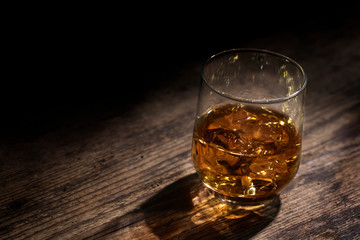 Glass of Whiskey Against Dark Rustic Background