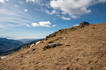View from a high mountain overlooking a large valley with mystical mountains far away.