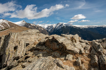 Overlooking a snowy mountain range with a rocky foreground.