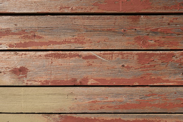 Wall of old boards with cracked red paint. Creative vintage background. Pine boards are red.