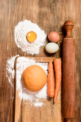 Orange carrot noodle dough bun, with ingredients on the table.