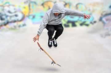Fototapeta na wymiar young skater doing jump trick at skate park .
