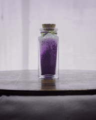 fancy bottle with lavender purple bath salts for relaxing spa treatments with white background
