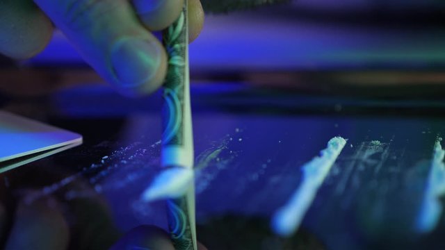 Silver tray with powder drugs, money and pills. Man draw in or sniff white drug . Drug addict concept: hard drugs prepared for consumption. Cocaine, amphetamine, meth