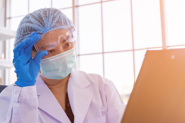 An Asian female scientist is researching a chemical formula in a lab.