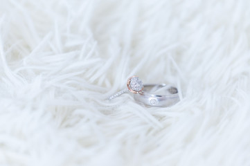 Obraz premium The diamond wedding ring for the bride and groom's wedding ring is made of white gold. And large high-value diamonds lay on the woolen rug Concept of important, wedding day celebration