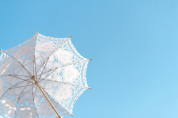 White cloth umbrella made of stencil fabric, fabric that looks like a dash of flowers. Used an umbrella for decorating a festive wedding. It helps to look shady. Used in wedding ceremonies. © DJSPIDA FOTO