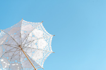 White cloth umbrella made of stencil fabric, fabric that looks like a dash of flowers. Used an...