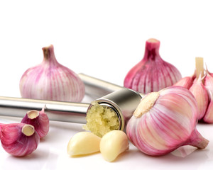 Garlic press and garlic on white background 