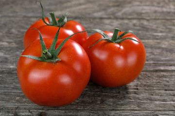 Drei frische rote Tomaten auf rustikalem Holzuntergrund