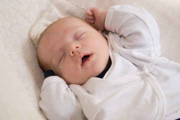 Süßes Baby schläft mit offenem Mund