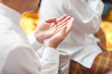 Asian religion, Muslim young man Raise both palms To ask for blessings from God according to the doctrine of religion Dressed in polite local costumes