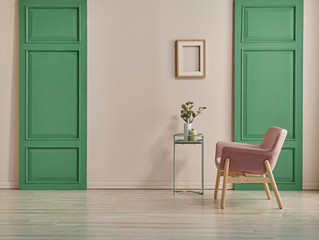 Decorative pink chair and green door style with frame and coffee table. pink wall background.