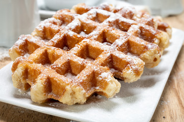 Tasty Belgian dessert, Brussels waffles with syrup and white sugar powder
