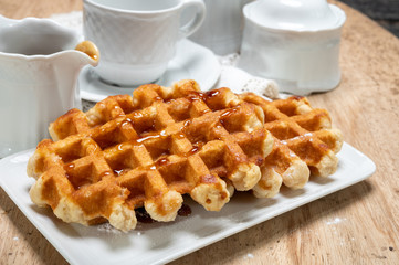 Tasty Belgian dessert, homemade Brussels sugar waffles with dark syrup