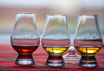 Special tulip-shaped glasses for tasting of Scotch whisky on distillery in Scotland, UK and red tartan
