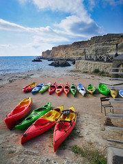 Kayaks lie on the shore near the sea without people. Tourist route and hobby water sport