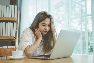 Lazy bored asian woman using laptop in the morning.