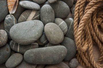 many gray pebbles with hemp rope background, space for text.