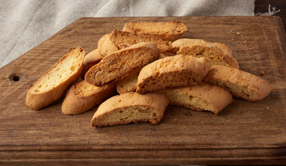 pieces of baked italian christmas biscotti cookies on a brown wooden board