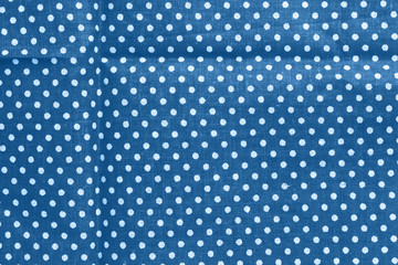 Polka dot on classic blue canvas cotton texture. Blue fabric with printed white circles. Bright...