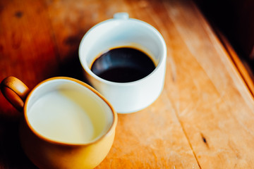 Hot coffee and milk in white cup on the table in the morning