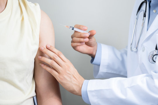 Asian man get coronavirus, flu and measles vaccine shot, vaccination in hospital for good heath, medicine injection vial dose for treatment patient. (select focus)