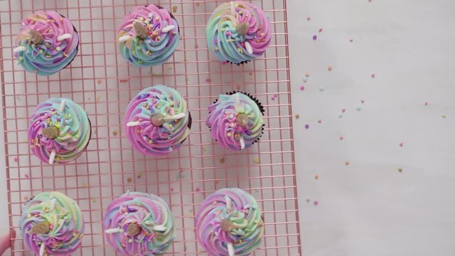 Flat lay. Step by step. Frosting unicorn chocolate cupcakes with rainbow color buttercream frosting.