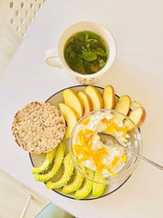 Breakfast for health. Curd with acacado slices apples and dietary breads with green tea.