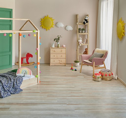 Decorative child room with wooden bed cabinet and pink chair interior decor.