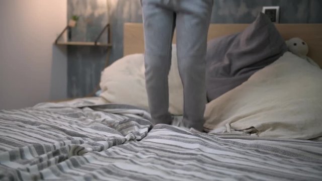 legs of a kid jumping on the bed, end of action