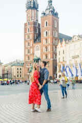 a young couple is stylishly dressed, a girl in a red dress, a man in a blue shirt and blue pants,...