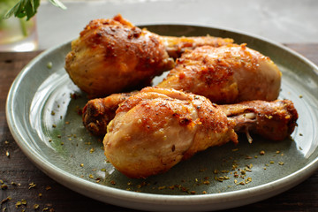 Fried chicken legs in a plate with vegetables. Tasty lunch or dinner. Barbecue, grilled meat. Chicken thighs and drumsticks.