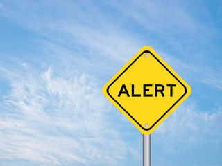 Yellow transportation sign with word alert on blue sky background