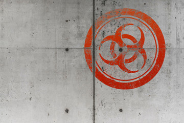 grungy red biohazard warning symbol on rough concrete wall background