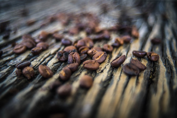  The coffee beans spilled on a wooden table with natural stripes.